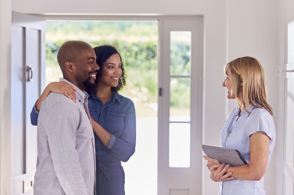 Couple Viewing Potential New Home With Female Realtor