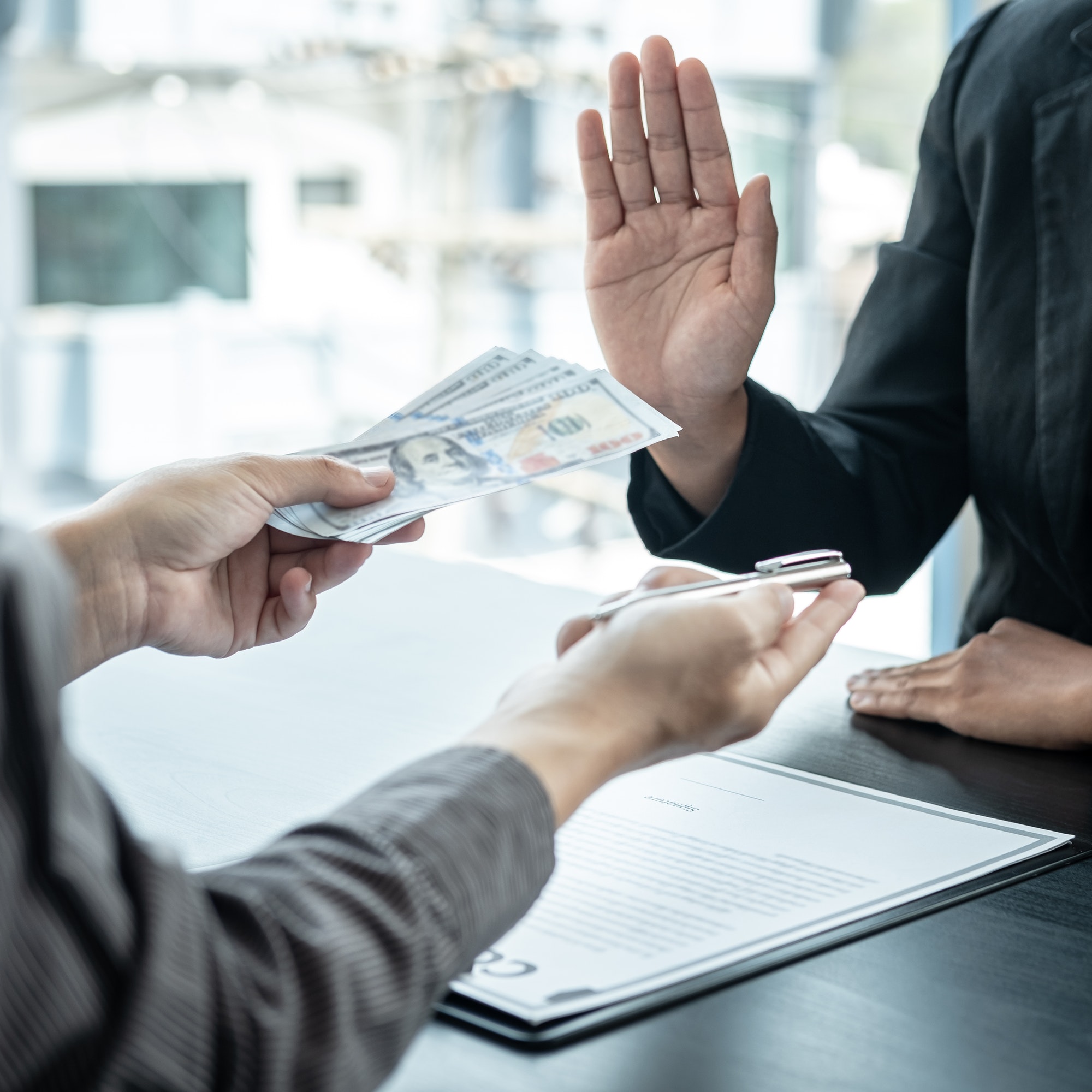 Man employee offering bribe money to business woman to signing the contract to joint engage